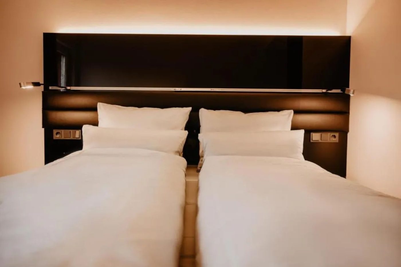 Doppelzimmer mit zwei Betten und indirekter Beleuchtung